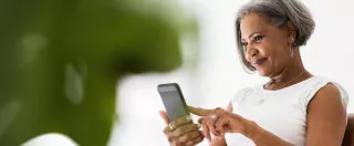 Woman looks at her phone, smiling