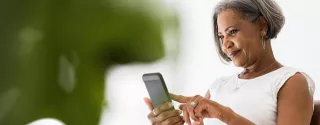 Woman looks at her phone, smiling