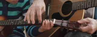 2 people learn the guitar