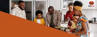 Image of a family gathered in the kitchen, smiling and laughing